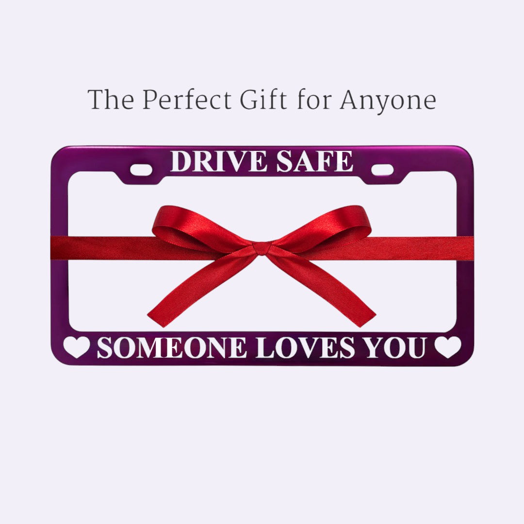 GoPlates custom purple anodized aluminum license plate frame with laser-engraved text and a decorative red gift bow.